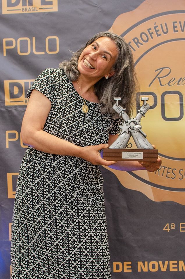 Isabel Arnold segurando seu Troféu Evidência 2019, durante o evento